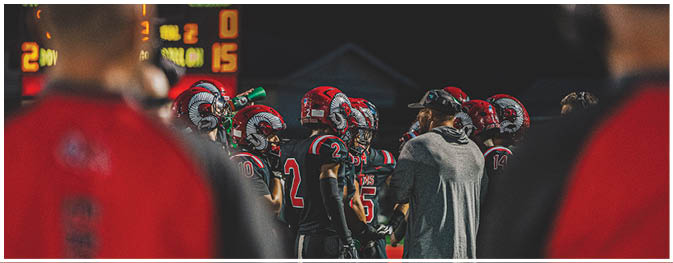 A group of football players on a field. Description generated by AI