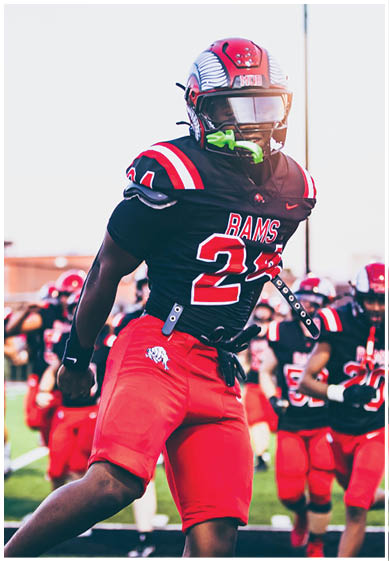 A football player wearing a blue and red jersey. Description generated by AI