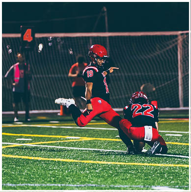 A football game is taking place with a group of men on the field. Description generated by AI