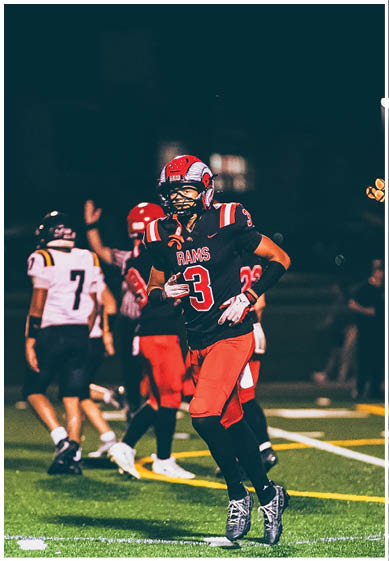 A football player wearing a blue and red jersey. Description generated by AI