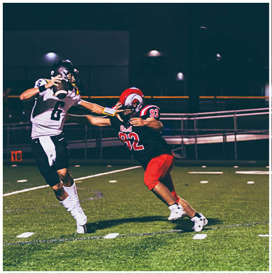 A football game is taking place with a group of men on the field. Description generated by AI