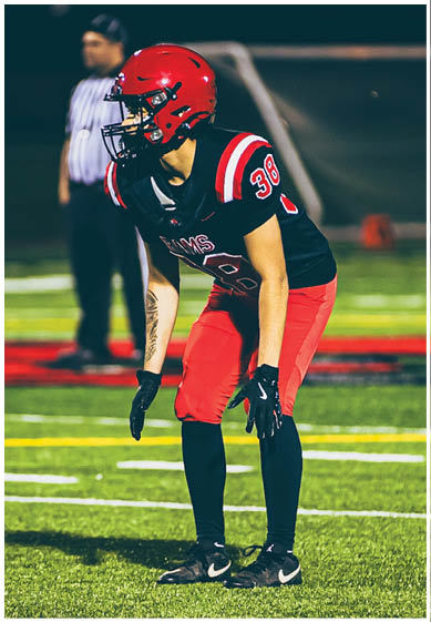 A football player wearing a blue and red jersey. Description generated by AI