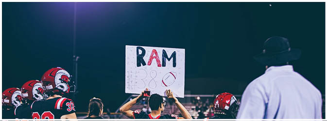 A football game is taking place on a field with players wearing blue and white uniforms. Description generated by AI