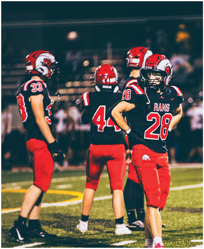 A group of football players on a field. Description generated by AI