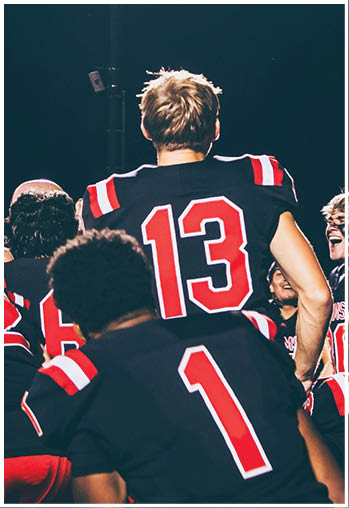 A group of football players celebrating a touchdown. Description generated by AI