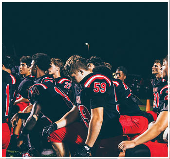 A group of football players celebrating a touchdown. Description generated by AI