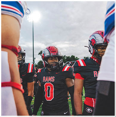 A football game is taking place with a group of men on the field. Description generated by AI