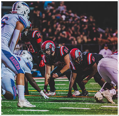 A football game is taking place with a group of men on the field. Description generated by AI