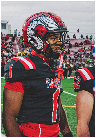 A football player wearing a blue and red jersey. Description generated by AI