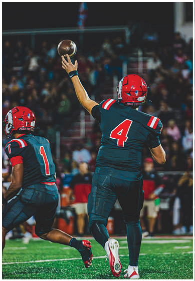 A football player wearing a blue and red jersey. Description generated by AI