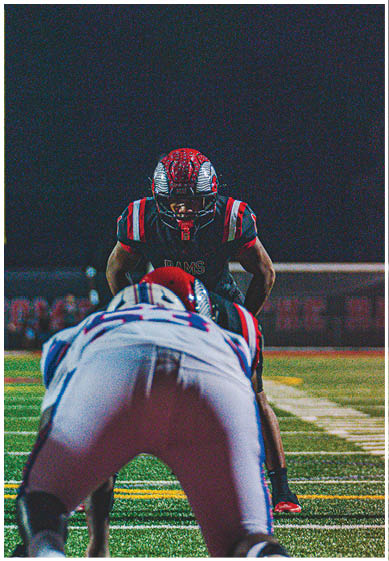 A football player wearing a blue and red jersey. Description generated by AI