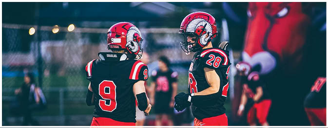 A group of football players on a field. Description generated by AI
