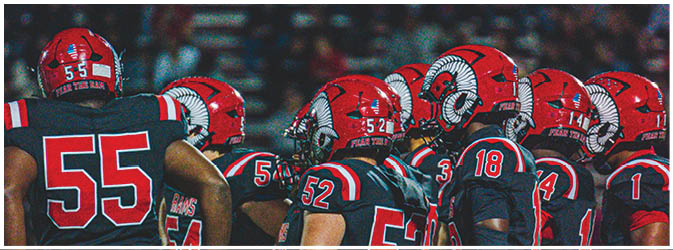 A football game is taking place on a field with players wearing blue and white uniforms. Description generated by AI