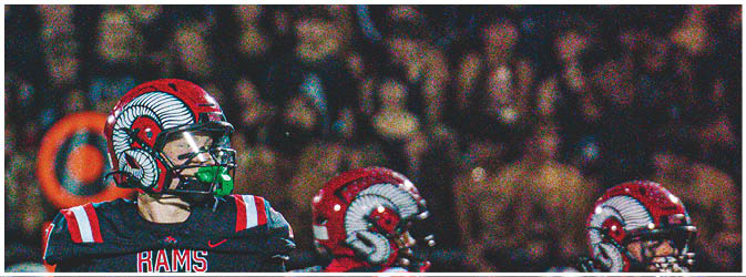 A football game is taking place on a field with players wearing blue and white uniforms. Description generated by AI