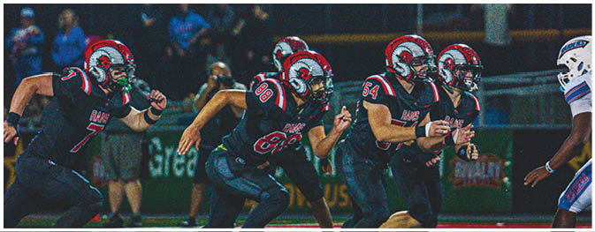 A group of football players on a field. Description generated by AI