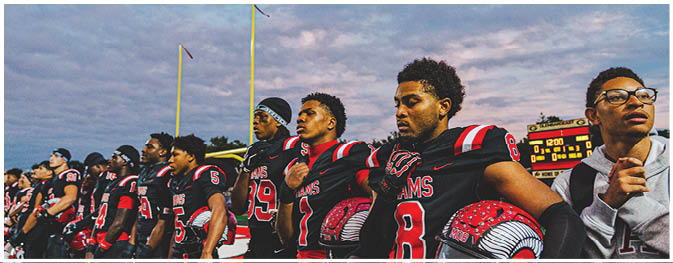 A group of football players on a field. Description generated by AI