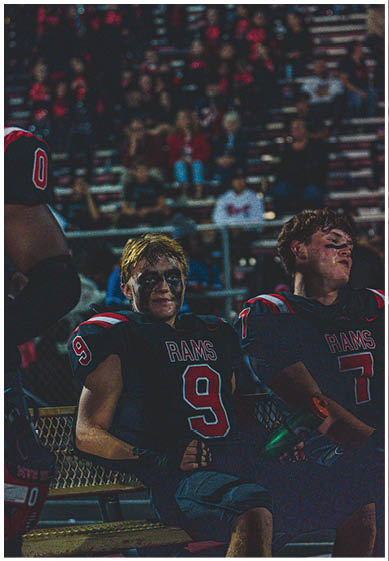 A football player wearing a blue and red jersey. Description generated by AI