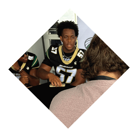A football player wearing a black jersey with the number 3 kneels on the field. AI generated content