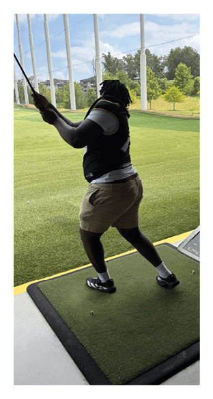 A man in a green shirt and black pants is preparing to throw a football. AI generated content