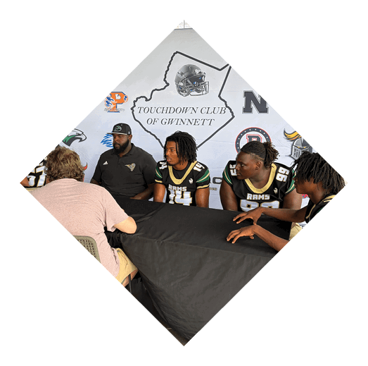 A football player wearing a black jersey with the number 16 on it is holding a football. AI generated content