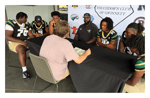 A group of football players wearing headphones and smiling. AI generated content