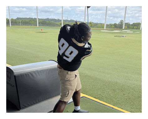 A man wearing a football uniform is jumping to catch a football. AI generated content