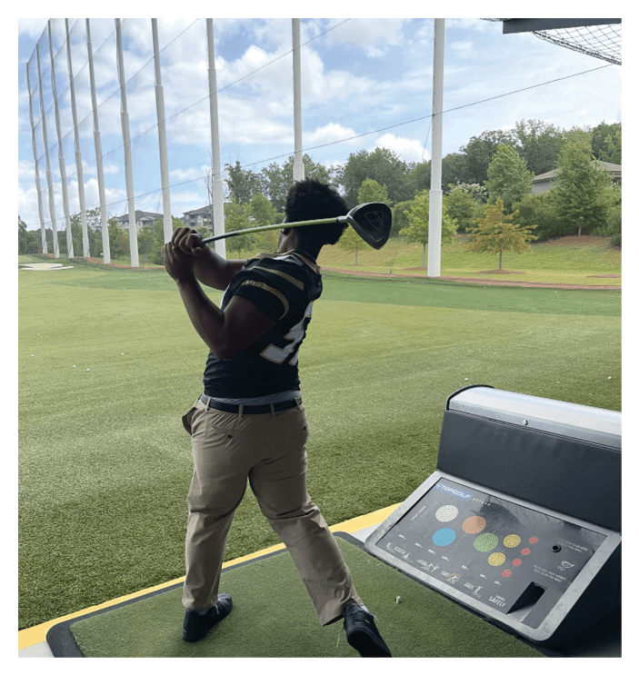 A football game is in progress with players on the field. One player is throwing a football while another player is trying to catch it. The players are wearing uniforms and are actively engaged in the game. AI generated content