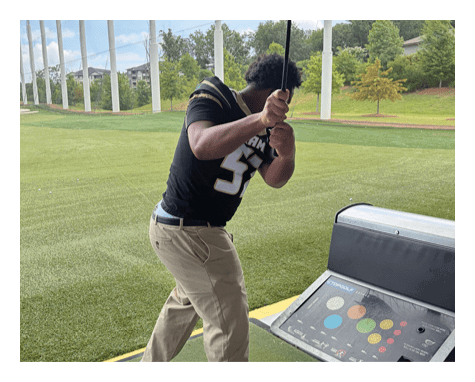 A man in a black jersey is running on a field with a football in his hand. AI generated content