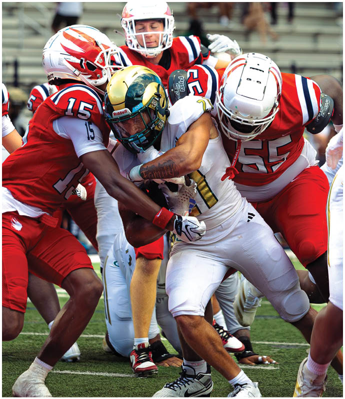 Three football players in blue and white uniforms running on a field. Description generated by AI