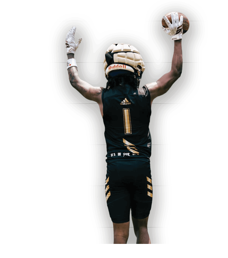 A person wearing a padded helmet and black athletic gear with the number one on the back raises both arms in celebration or victory. Description generated by AI