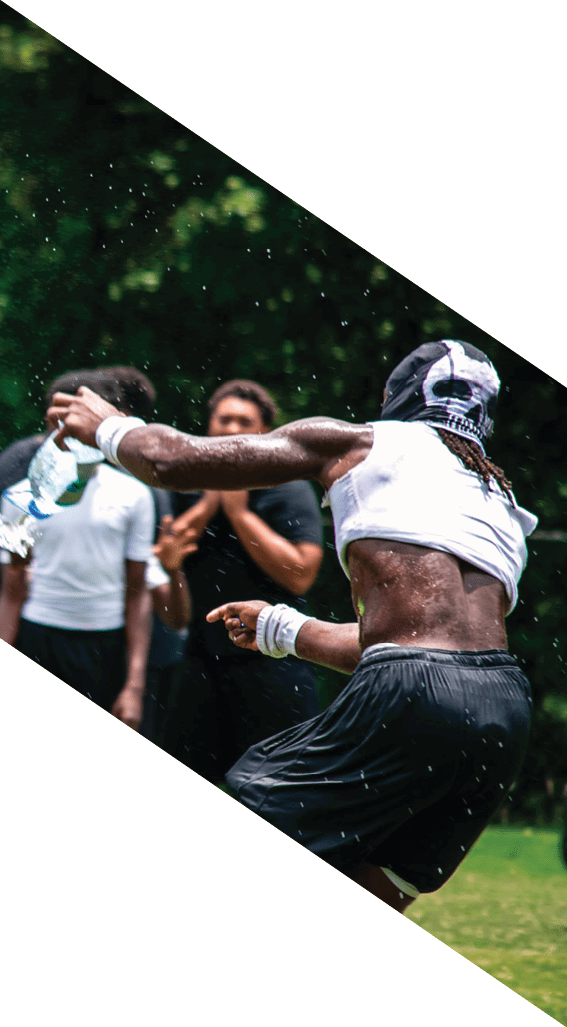 A football player wearing a black helmet and white jersey is holding a football in his hands. AI generated content