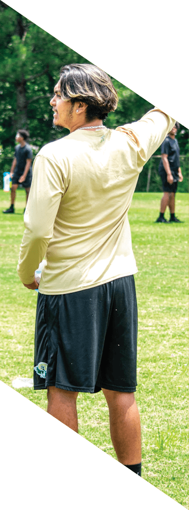 A young man wearing a football uniform is smiling and laughing. AI generated content