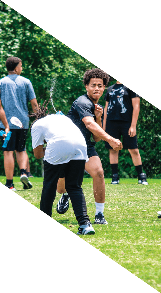 A football player wearing a black helmet and white jersey is holding a football in his hands. AI generated content