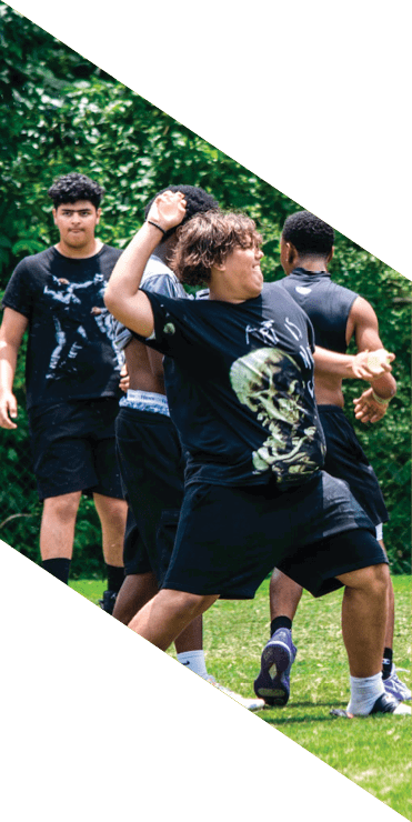 Two football players are on the field, one jumping in the air while the other is running. A referee is also present, watching the play. AI generated content