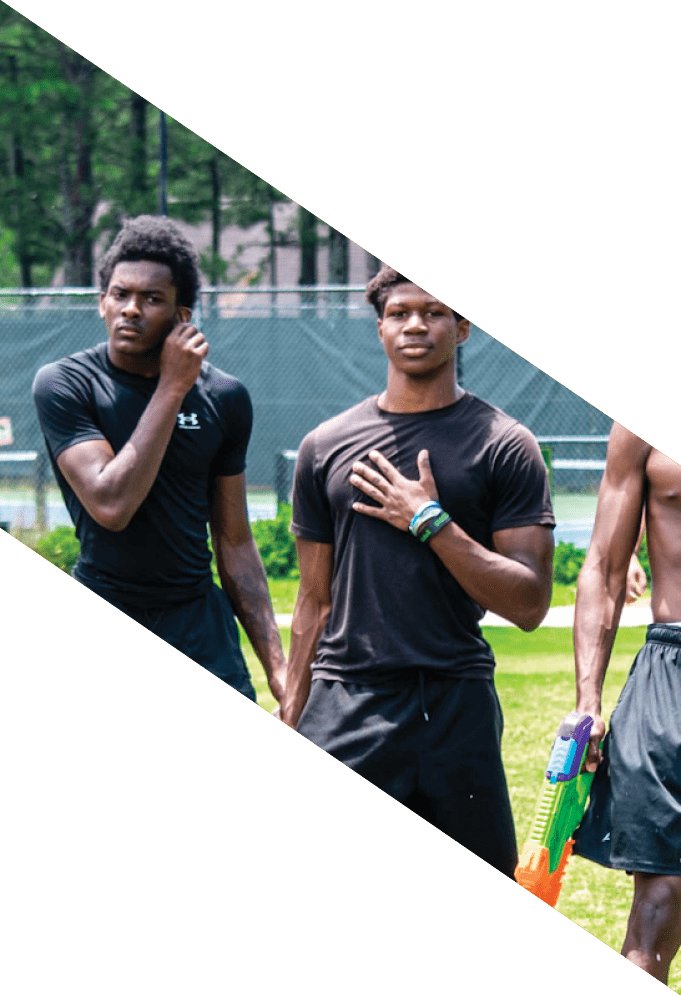 Three football players wearing green uniforms and black helmets pose for a photo. AI generated content