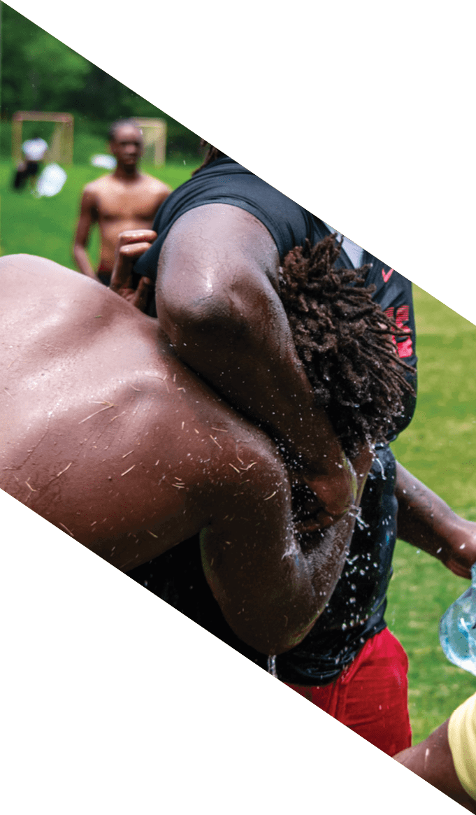 A group of people wearing black jerseys are huddled together on a field. AI generated content