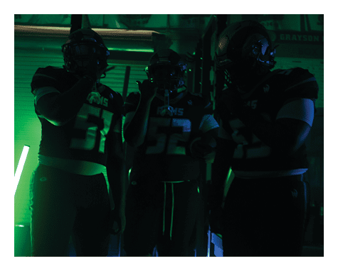 Two football players celebrating a touchdown with one player jumping in the air. AI generated content