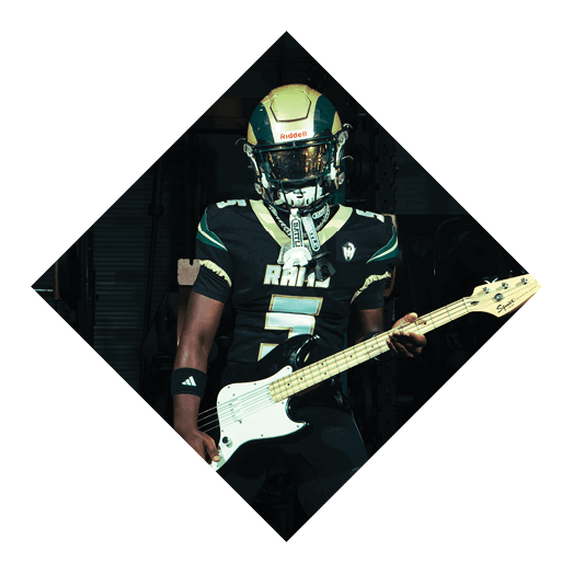A football player wearing a black jersey with the number 10 sits on the ground with a football helmet on the ground next to him. AI generated content