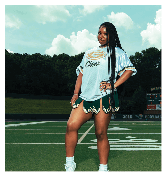 A football game is in progress with players on the field. One player is throwing a football while another player is trying to catch it. The players are wearing uniforms and are actively engaged in the game. AI generated content