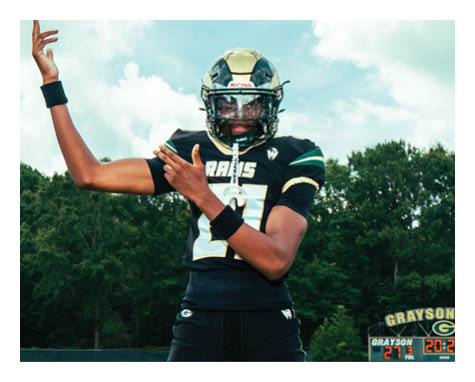 A man in a black jersey is running on a field with a football in his hand. AI generated content