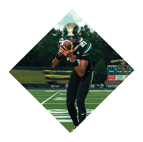 A football player wearing a black jersey with the number 3 kneels on the field. AI generated content