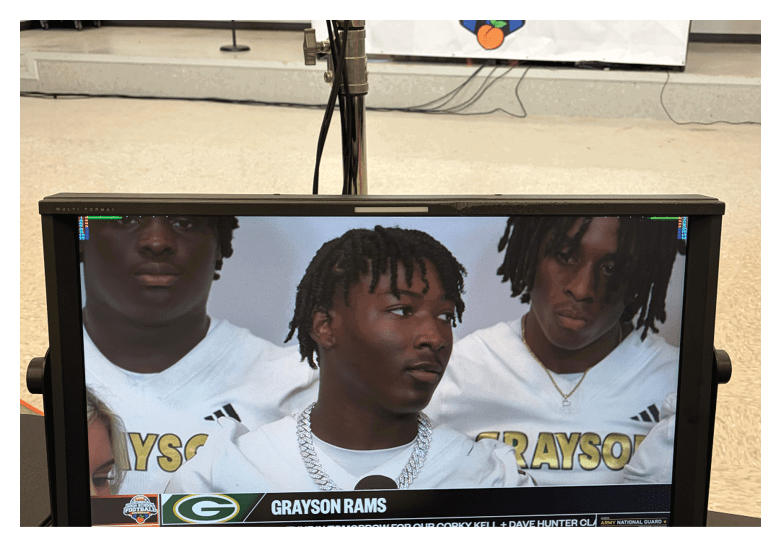 A group of football players on a field, one of them is running with a football. AI generated content