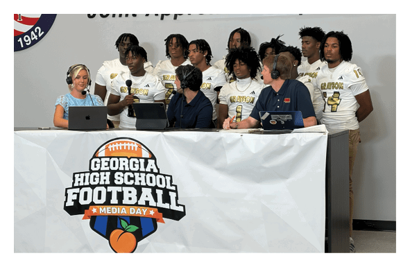 A group of football players wearing headphones and smiling. AI generated content