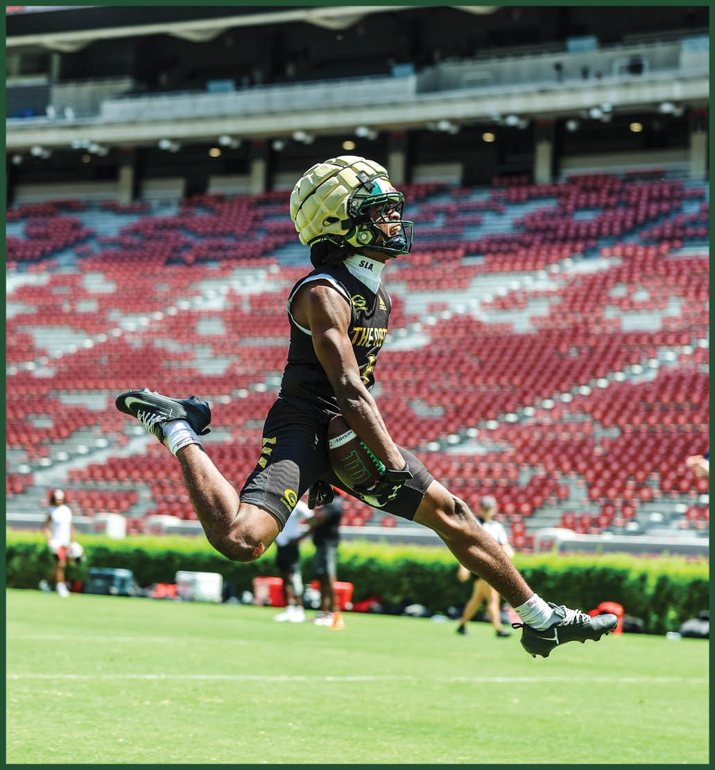 A football player in a green jersey is running with the ball. Description generated by AI
