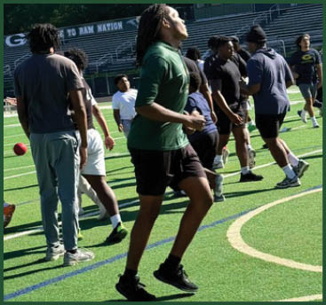 A group of football players on a field. Description generated by AI
