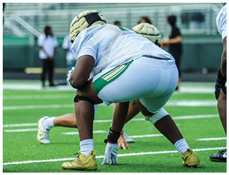 A group of football players on a field. Description generated by AI