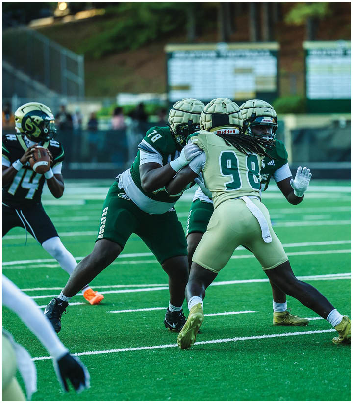 A group of football players wearing black and white uniforms. Description generated by AI