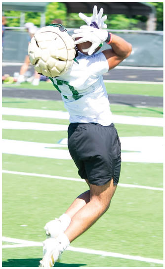 A football player catching a ball. Description generated by AI