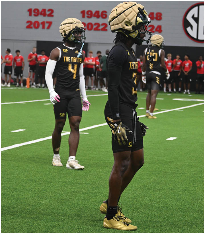 A group of football players wearing black and white uniforms. Description generated by AI
