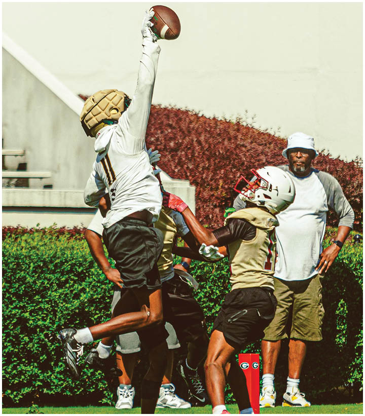 A group of football players wearing black and white uniforms. Description generated by AI